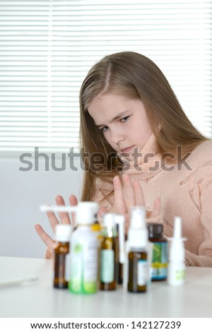 Portrait of a young girl in pink sweater feeling unwell