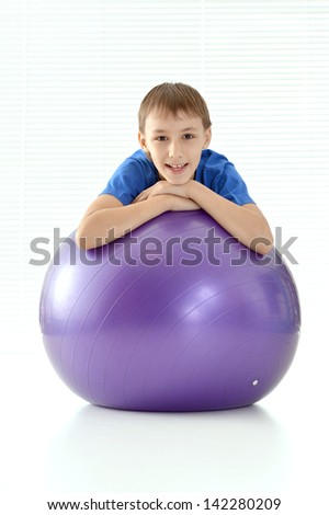 sporty young guy in a blue shirt with gymnastic ball