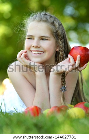 happy girl with apples resting in a park in spring