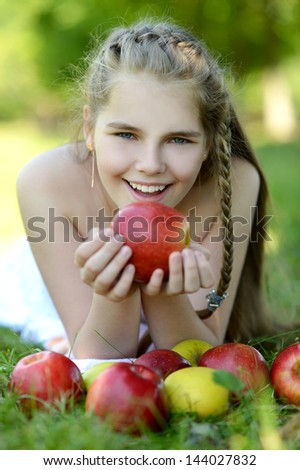 happy girl with apples resting in a park in spring