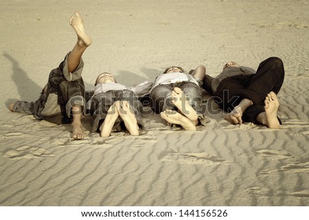 feet four persons lying on the sand