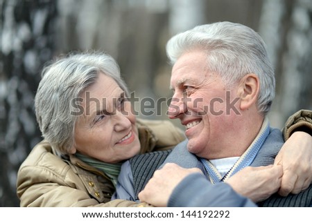 happy elder couple on a walk in nature in autumn