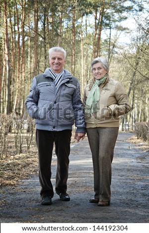 happy older couple on a walk in the forest in the spring