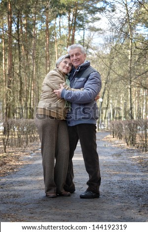 happy aged couple on a walk in the forest in the spring