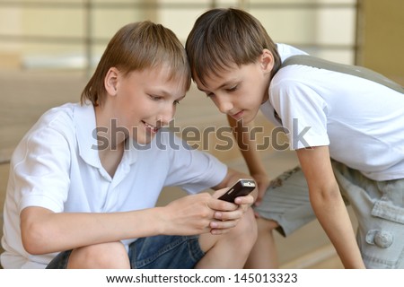 Two young guy playing the telephone game outdoors