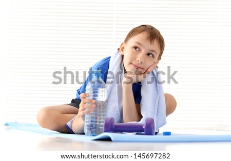 athletic young boy in a blue shirt on a light background