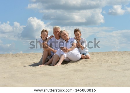 fun brothers with their grandparents walking on the sand in the summer