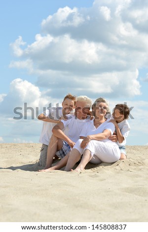 fun brothers with their grandparents walking on the sand in the summer