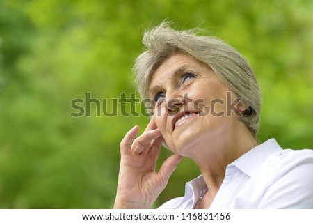 Portrait of an aged woman on a walk in the park in late spring