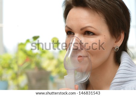 portrait of a young woman doing inhalation at home