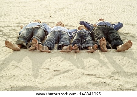 four persons lying on the sand