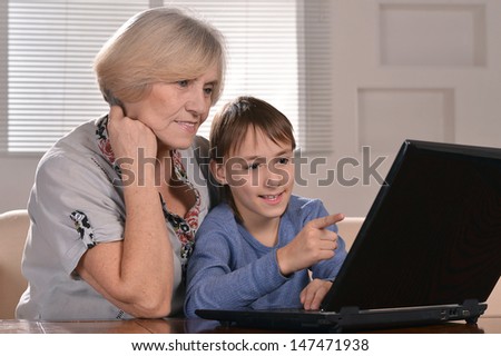 portrait of a boy and grandmother with a laptop at home