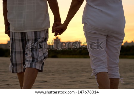 Elderly happy couple walking together from the back