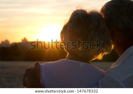 elderly couple in love at sunset on a summer evening