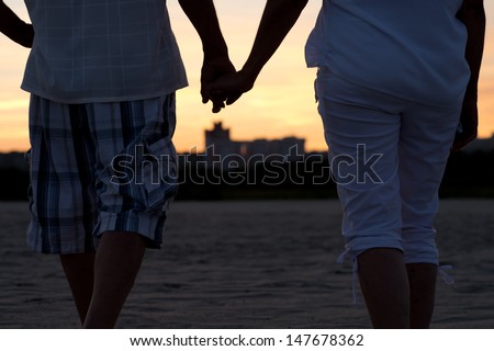 Elderly happy couple walking together from the back