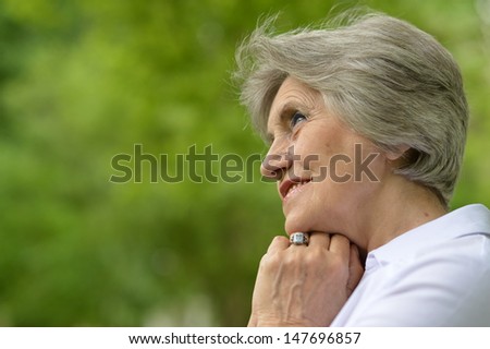 Portrait of a senior woman on a walk in the park in late spring