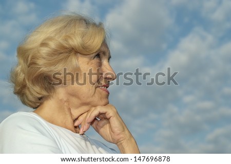 portrait of a beautiful senior woman on the background of sky