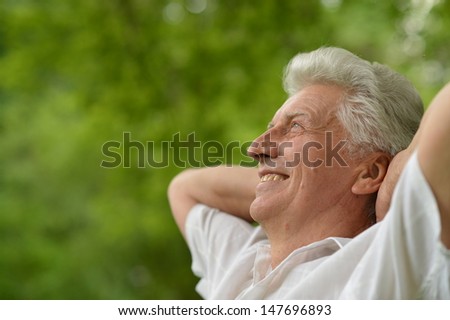 portrait of an elderly man walking in the forest in summer