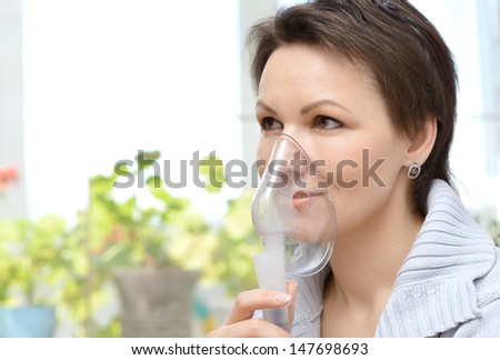 portrait of a young woman doing inhalation at home