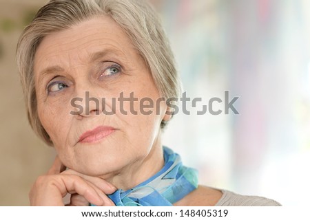 Portrait of an old woman with a blue neck scarf home
