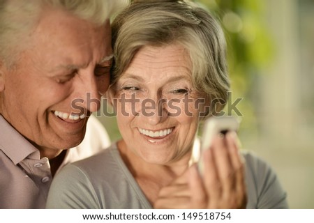 Happy elderly couple with a mobile phone