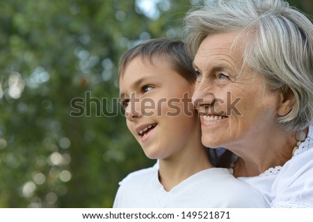 happy grandmother with her grandson for a walk in a summer park