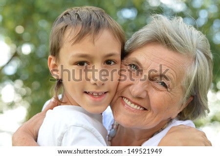 happy grandmother with her grandson for a walk in a summer park