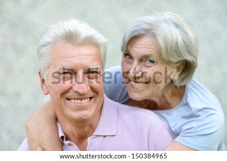 Happy senior couple on a gray background