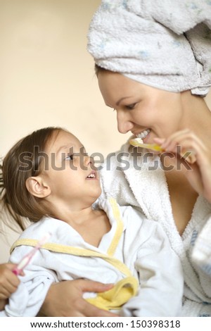 Mom and her little daughter in white bathrobes