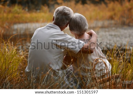 Old man and woman looking at lake