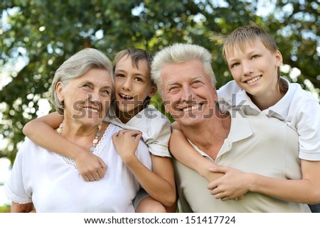 Older man and woman with their grandchildren having fun outdoors