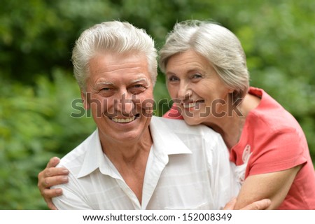 Loving aged couple on a background of trees
