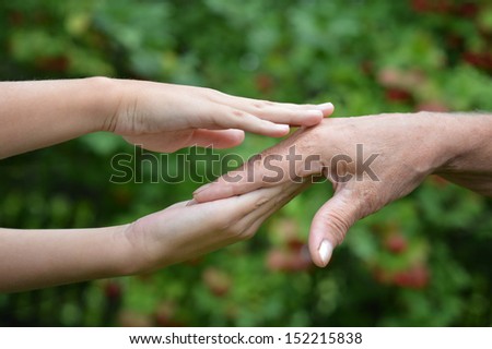 Two hands together against the green natural background
