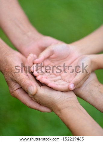 Three pairs of hands are held together. Care concept