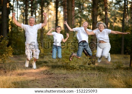 Portrait of a cheerful boys with his grandparents having fun in summer forest
