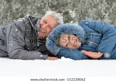 happy elderly couple having fun in winter park