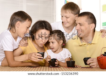 Family drinking tea at table in kitchen