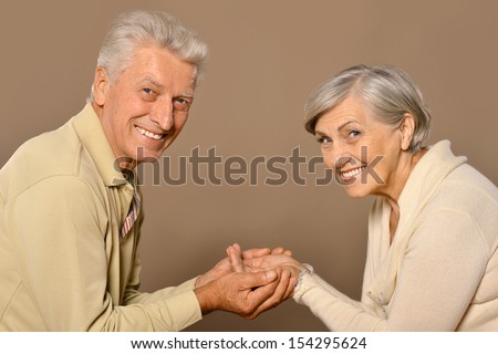 Happy older pair on a light brown background