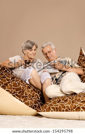 Cute old couple sutting and reading newspaper