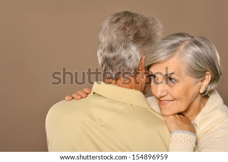 Happy older pair on a light brown background
