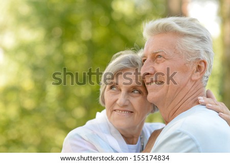Happy elderly couple at nature on leaves background