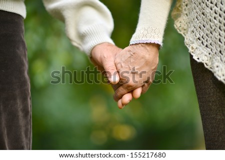 Hands held together on a natural green