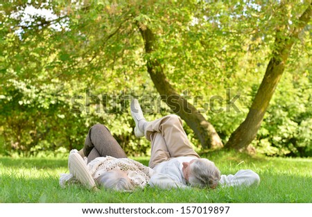 Happy senior couple lying in autumn park