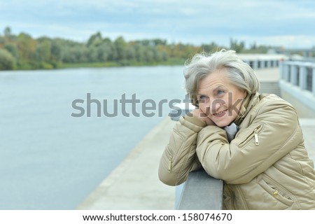 beautiful older woman walking in the park alone