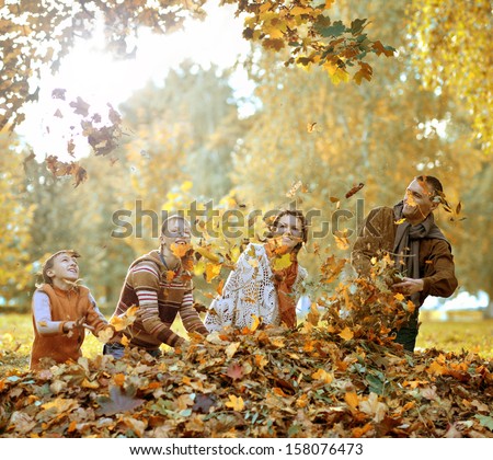 beautiful happy family relaxing in the the park during autumn
