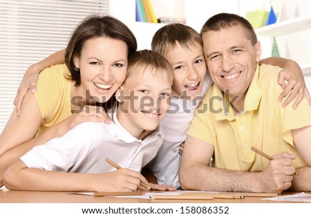 happy family drawing at the table together