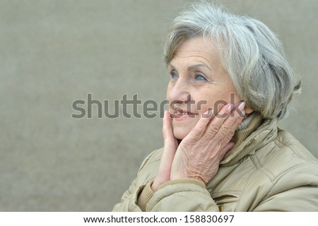 attractive elderly woman walking in the park alone