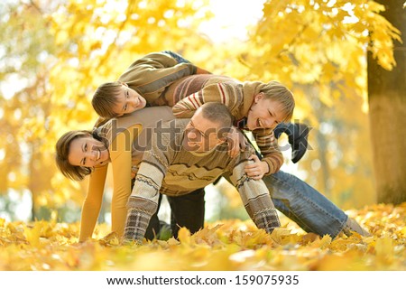united family on a walk during the fall of the leaves in the park