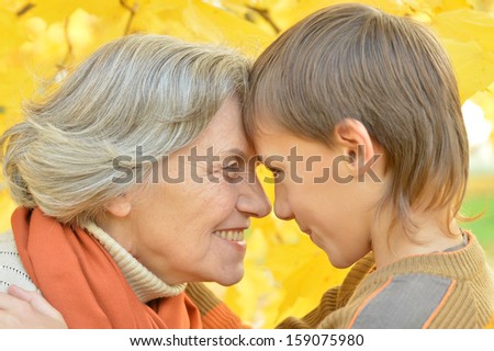 Grandmother and grandson for a walk during the fall of the leaves in the park