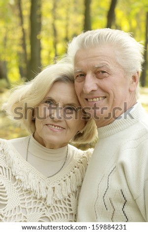 Smiling elderly couple resting in autumn park